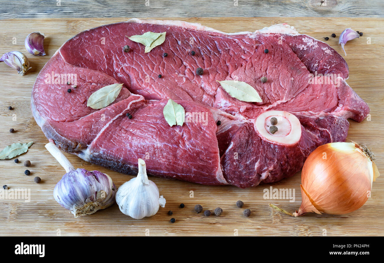 Raw beef hip part, onion head, bayleaf, bell pepper, garlic Stock Photo