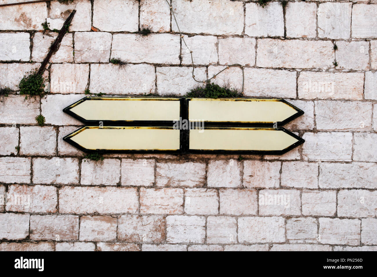 Roadmap signs and guidepost with a stone wall in background. Direction ...
