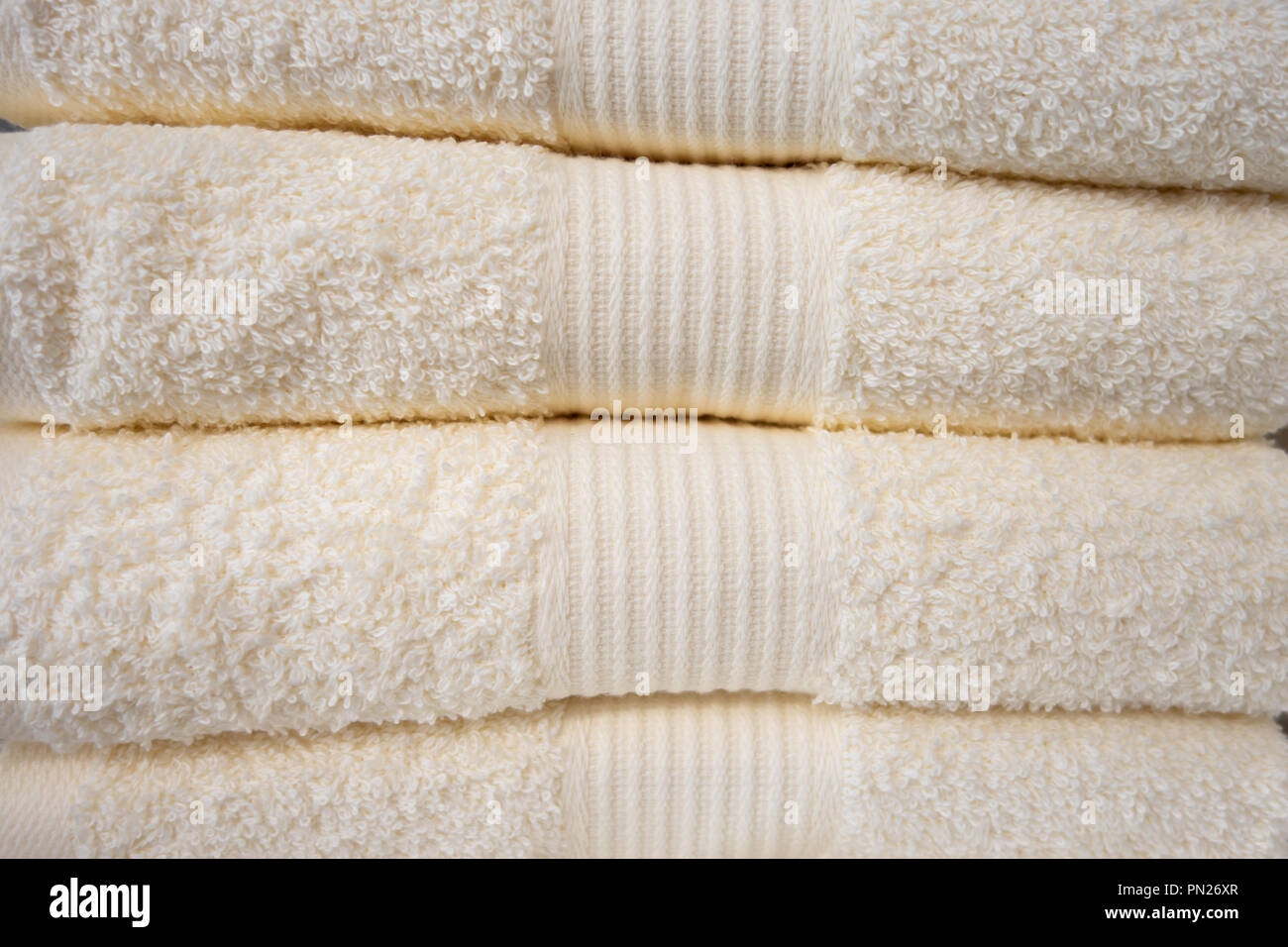 Clean towels. Many clean white towels are neatly stacked on the shelf
