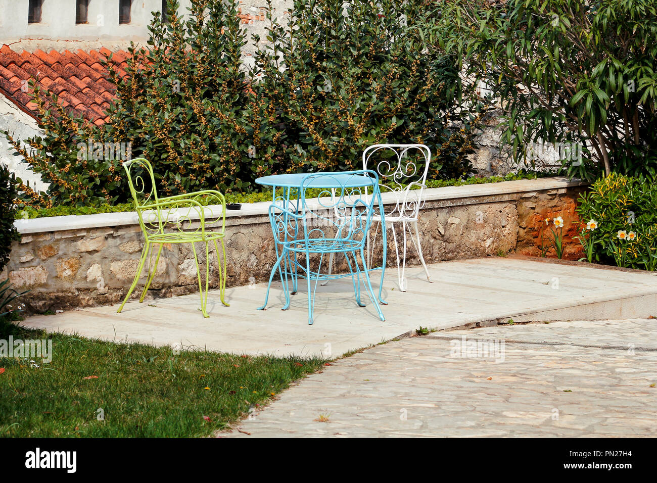 Chairs And A Table In Garden Colorful Steel Chairs And A Table Standing In A Beautiful Garden At Sunny Day Patio Furniture A Set Of Three Colored Stock Photo Alamy