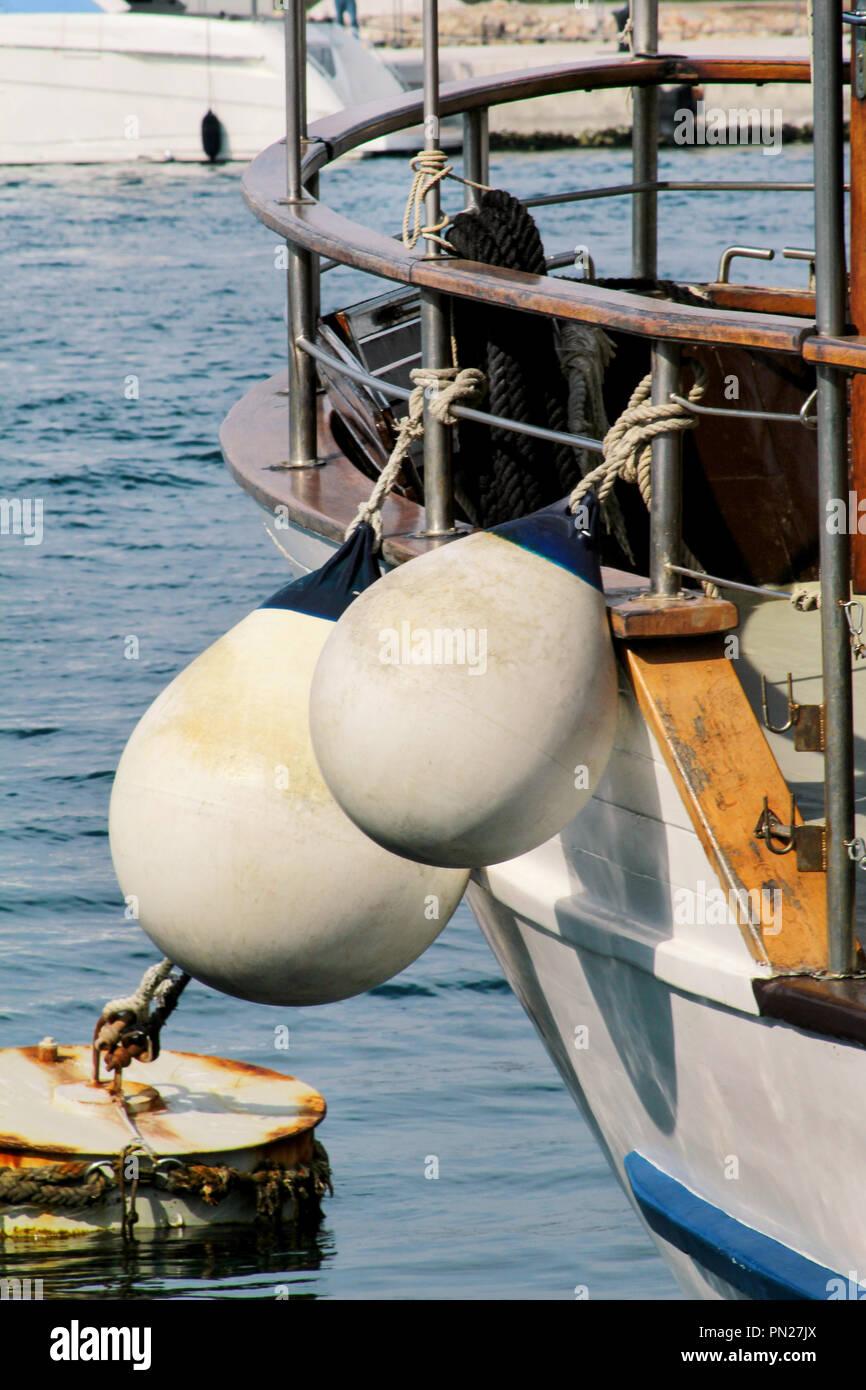 Buoys and anchor ropes, close up. White buoys on fishing boat anchored
