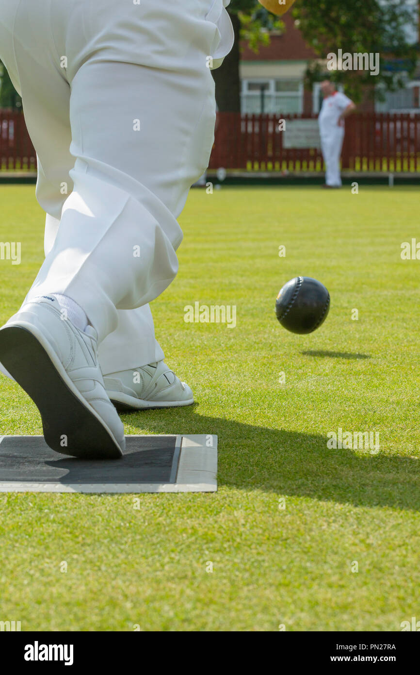Men playing bowls on a  village bowling green. Stock Photo