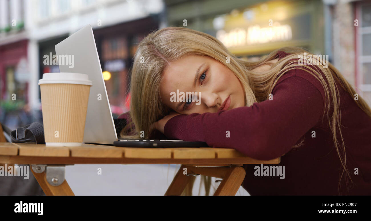 Stunning Caucasian beauty resting from work looks at camera mesmerizingly Stock Photo