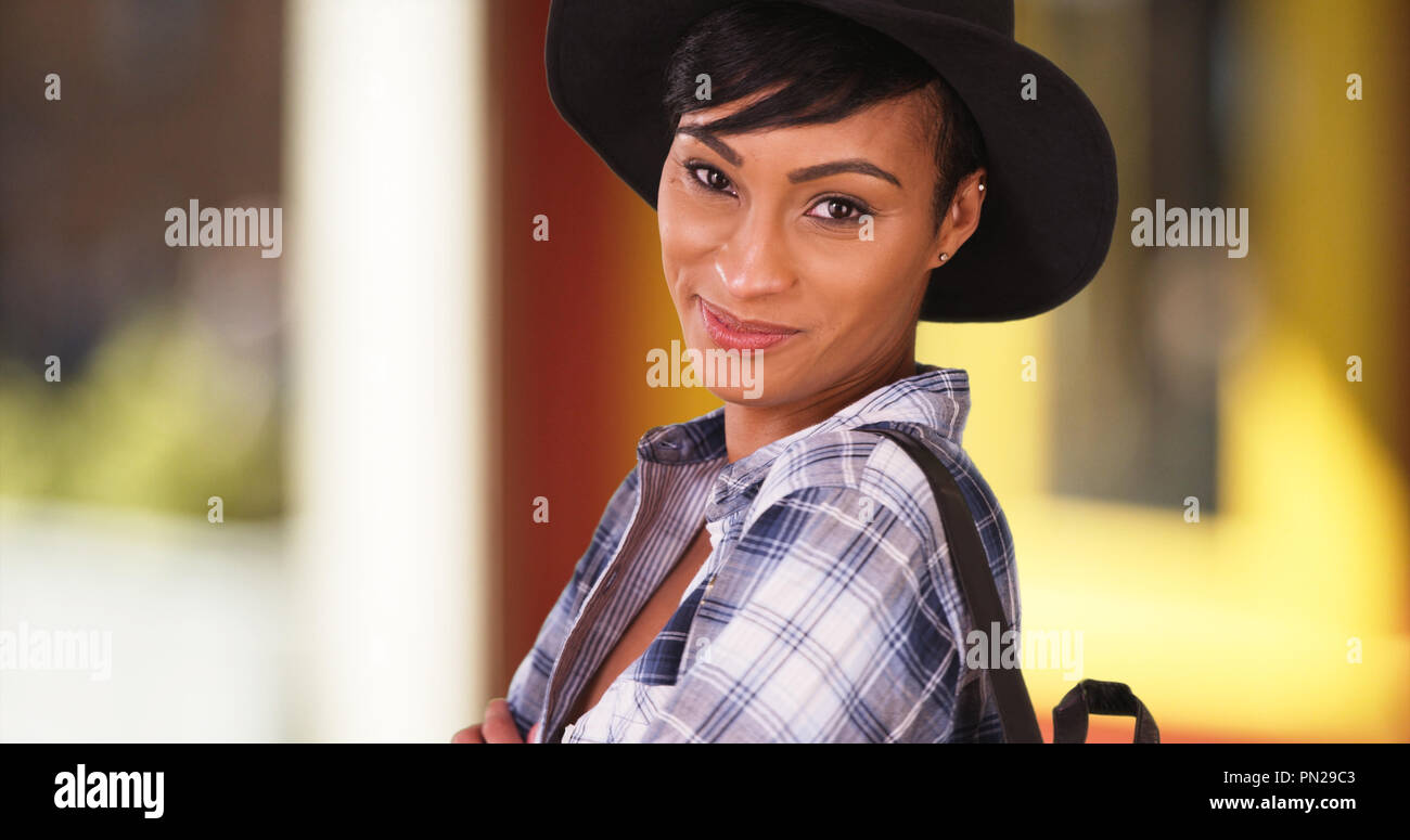 Happy smiling black woman on sunny city street wearing hat Stock Photo ...