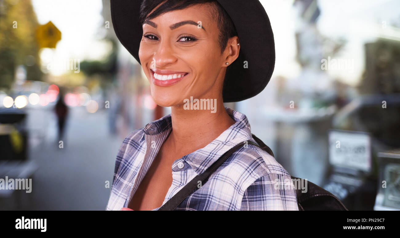 African American woman smiling on busy city street Stock Photo - Alamy