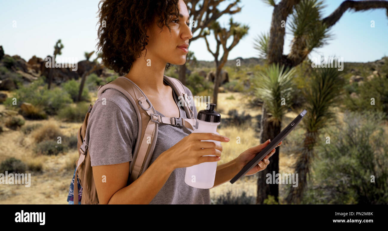 Pretty lost traveler looking at tablet computer in Joshua Tree Stock Photo