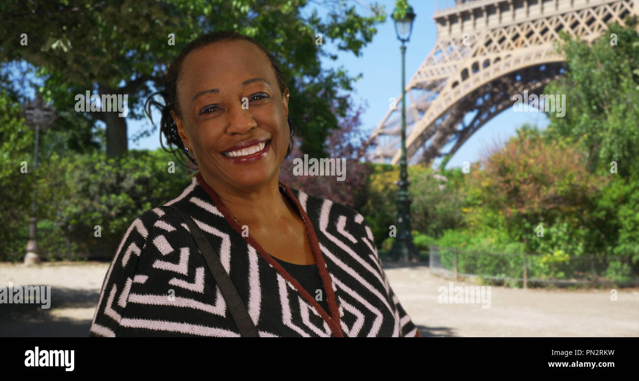 Portrait of happy retired African American woman standing near Eiffel ...
