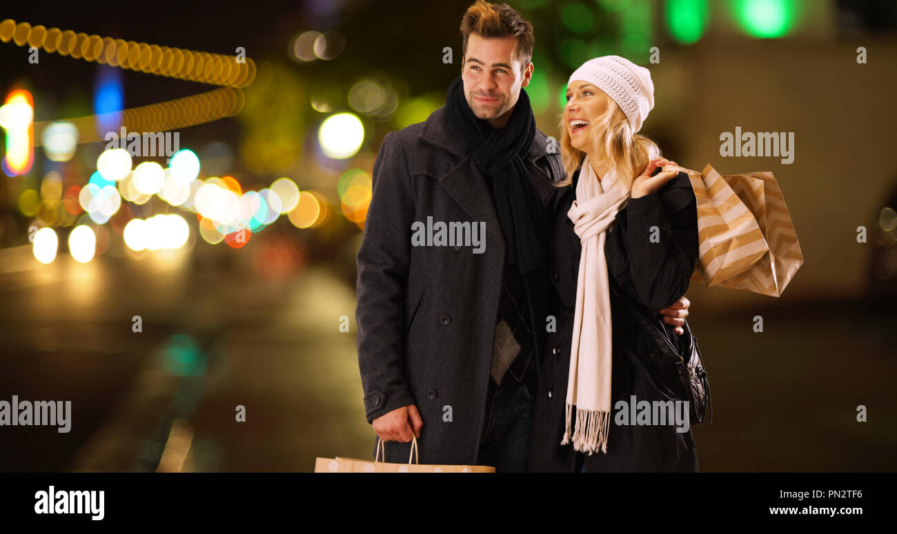 Young couple standing outside with shopping bags Stock Photo