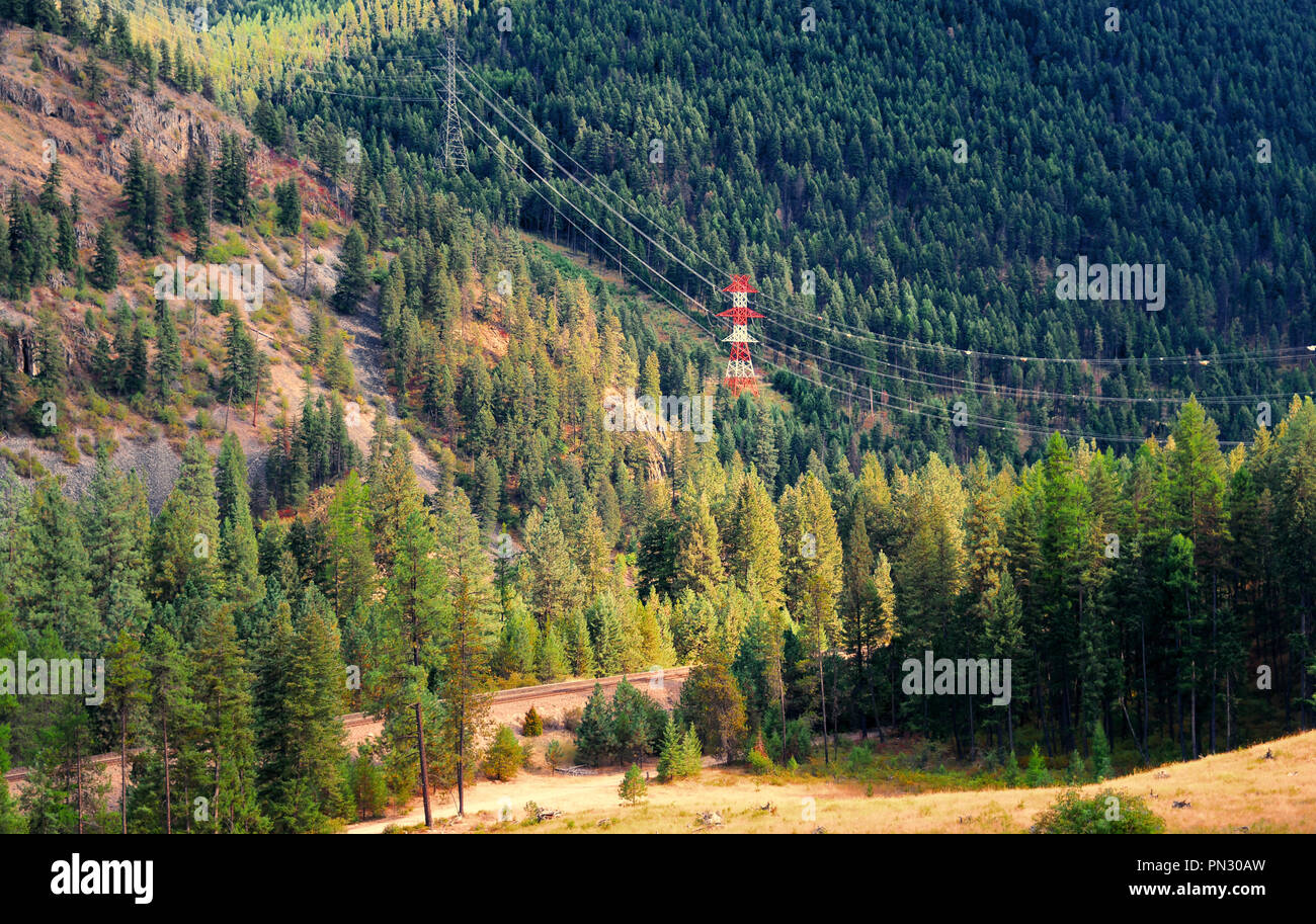 Electrical towers connecting lines across a valley and going up the side of a mountain Stock Photo