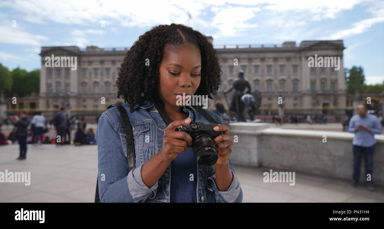 Portrait of excited tourist taking photos with camera outside Buckingham Palace Stock Photo