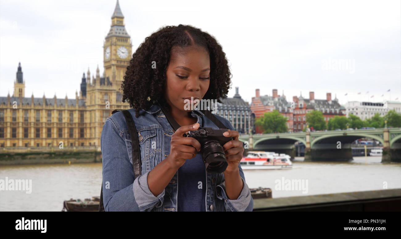 Portrait of black woman standing by River Thames in London taking ...