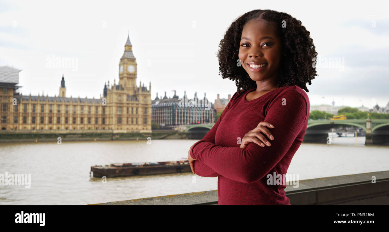 Smiling portrait of attractive black woman standing by River Thames ...
