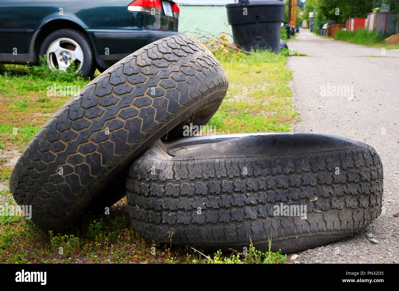 Old flat tires near a backyard garage Stock Photo