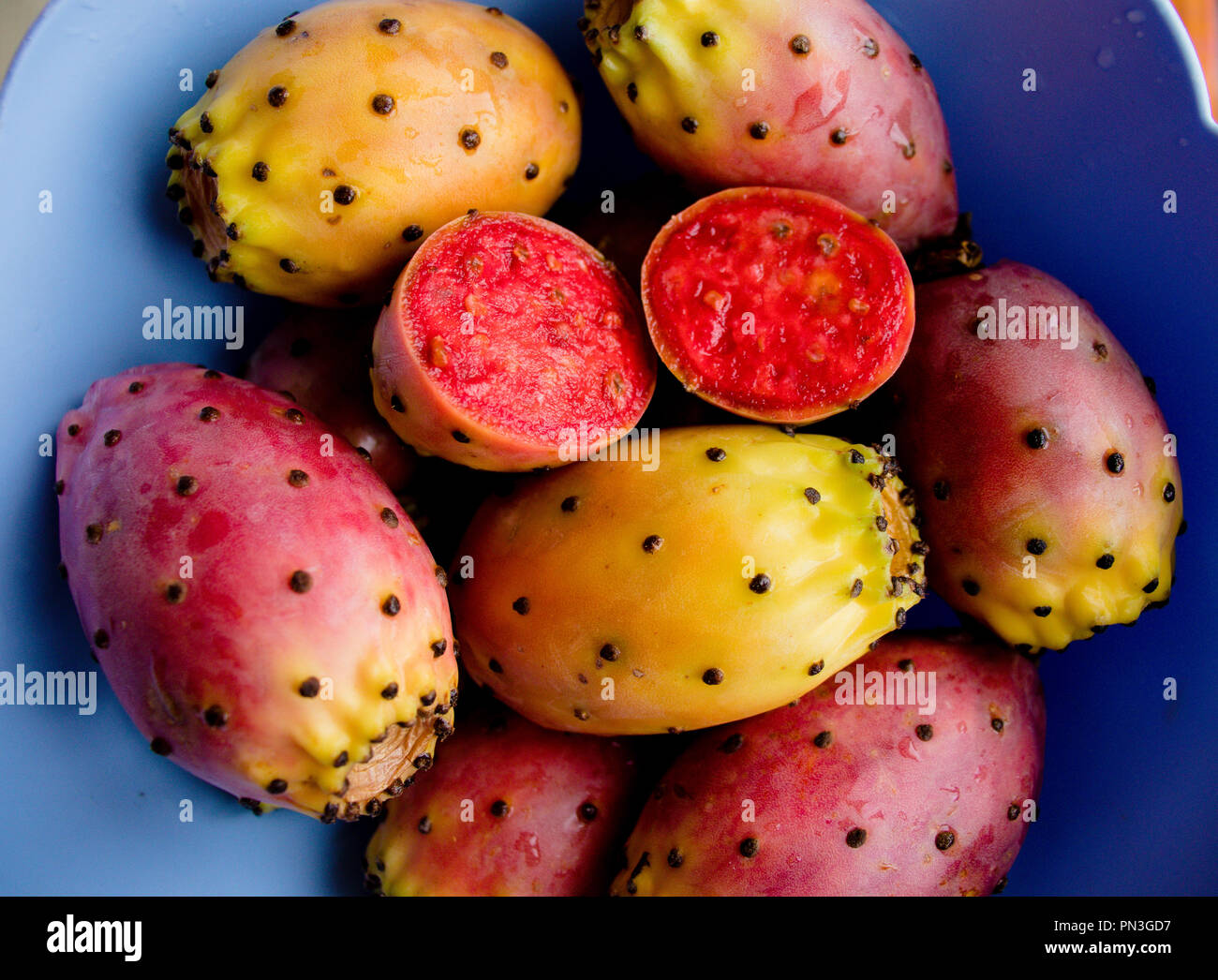 Prickly pear cactus colorful fresh ripe whole and cut fruits in bowl. Opuntia fichi d'india. South Italy. Top view. Close up. Food background Stock Photo