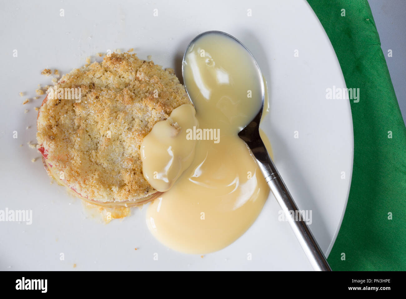 Classic English dessert of Apple crumble with Custard sauce Stock Photo