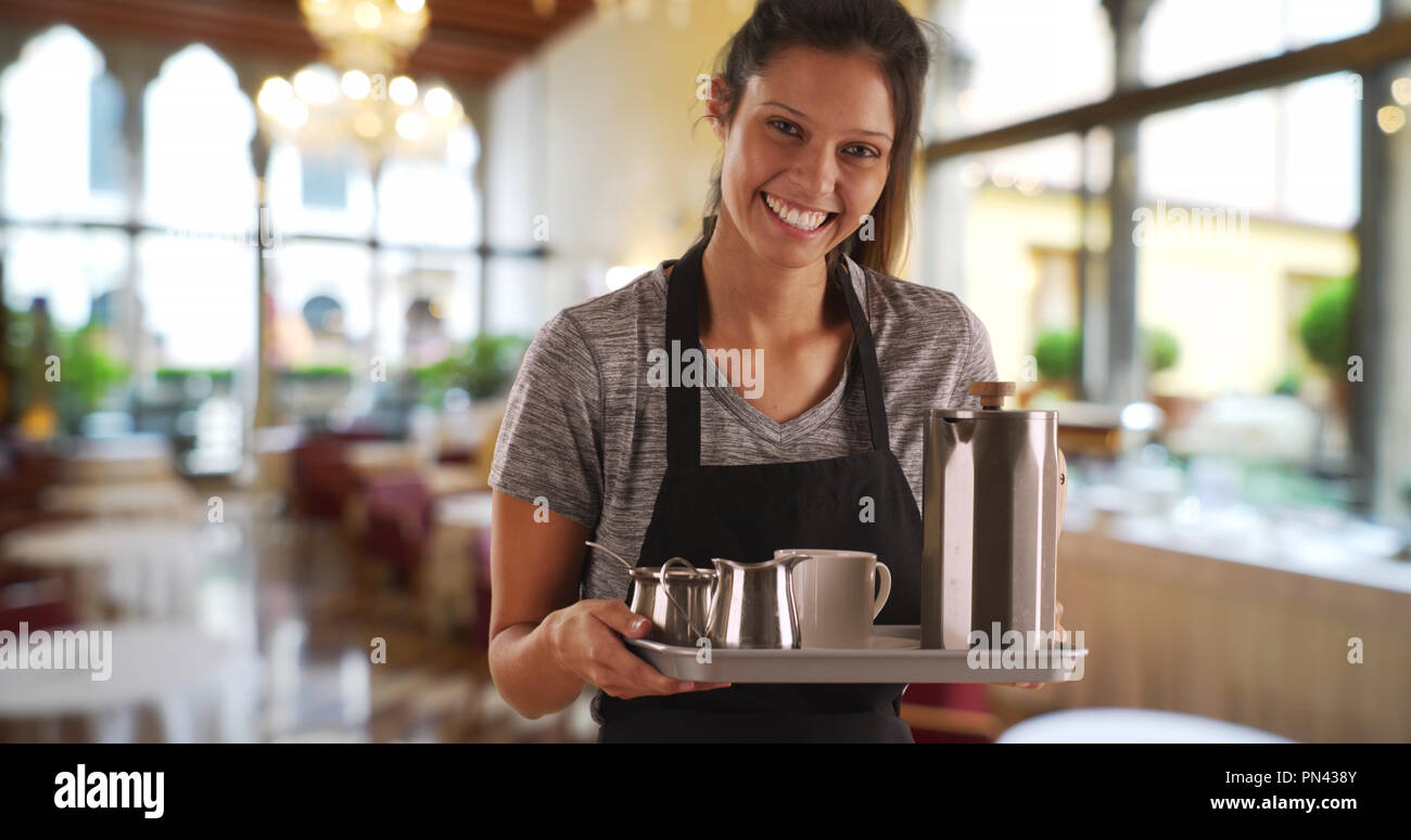 Pretty waitress in restaurant carrying tray with coffee beverages Stock