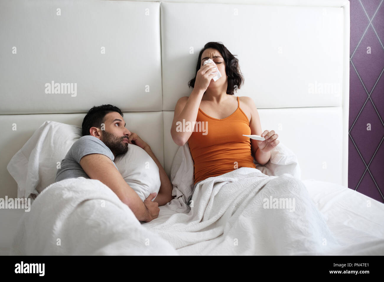 Young Woman Sneezing For Cold In Bed With Man Stock Photo Alamy