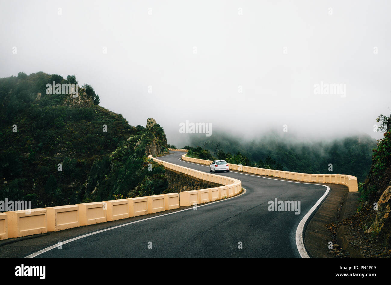 Car is on winding road im mist on north of Tenerife. Canary Islands, Spain Stock Photo