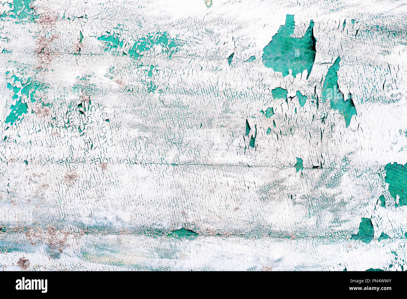 Cracked white paint layered on top of teal paint background texture Stock Photo