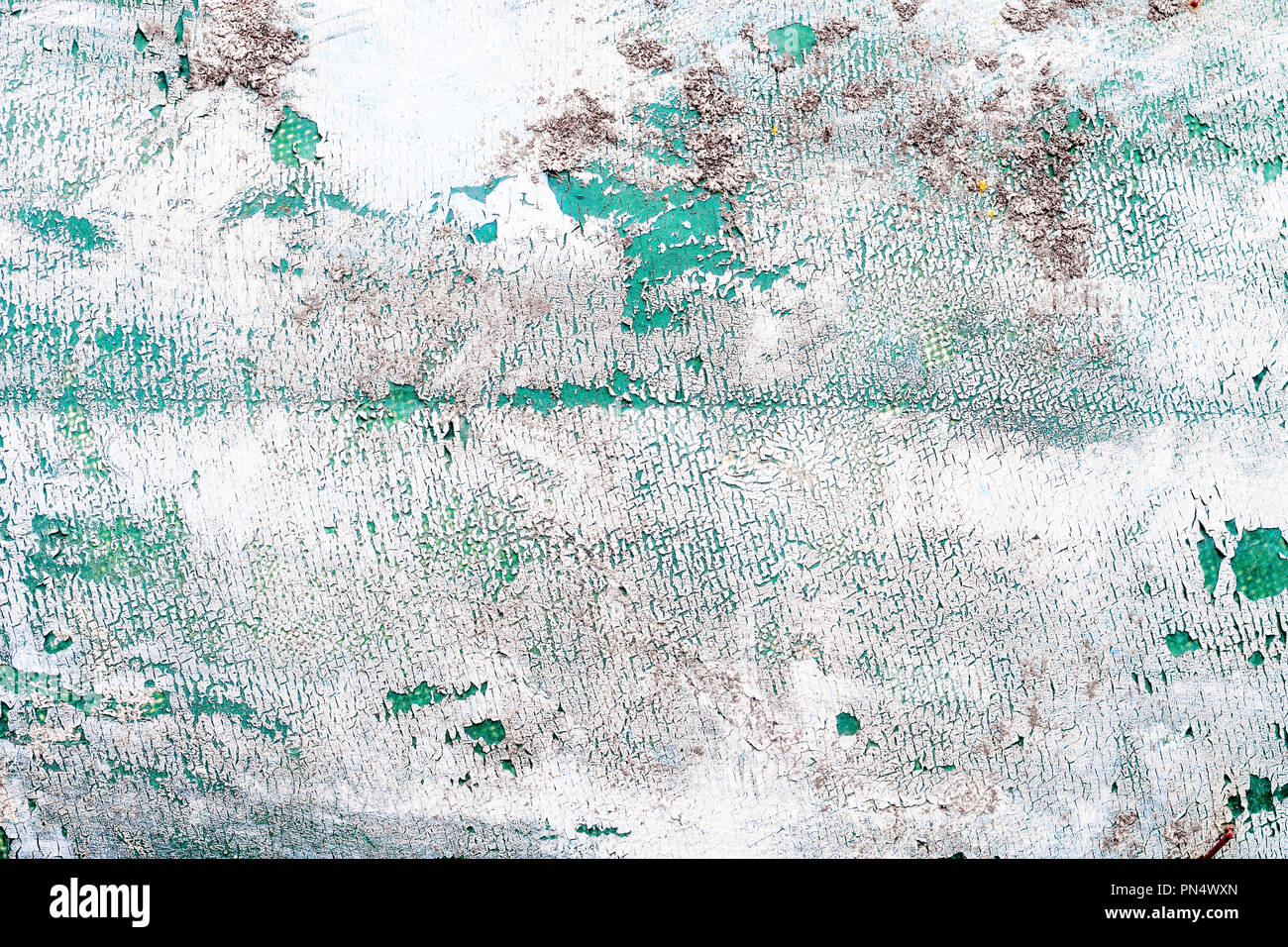 Cracked white paint layered on top of teal paint background texture Stock Photo