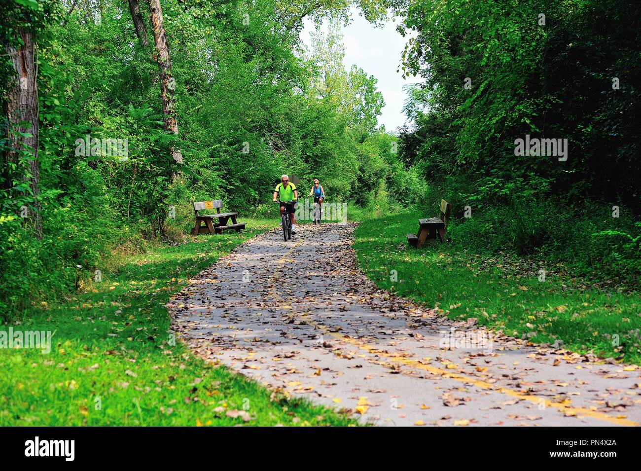 Palos Park, Illinois, USA. Pair of cyclists taking advantage of a bike trail along the Cal-Sag Trail named for the adjacent Cal-Sag Channel. Stock Photo