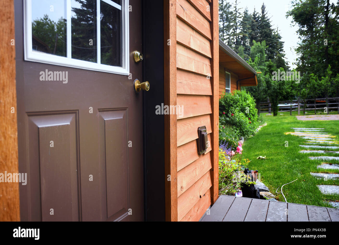 Close up of a cabin door with a garden behind it Stock Photo