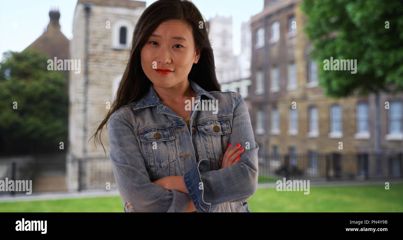 Chinese woman in denim jacket with arms crossed while on vacation in London  Stock Photo - Alamy