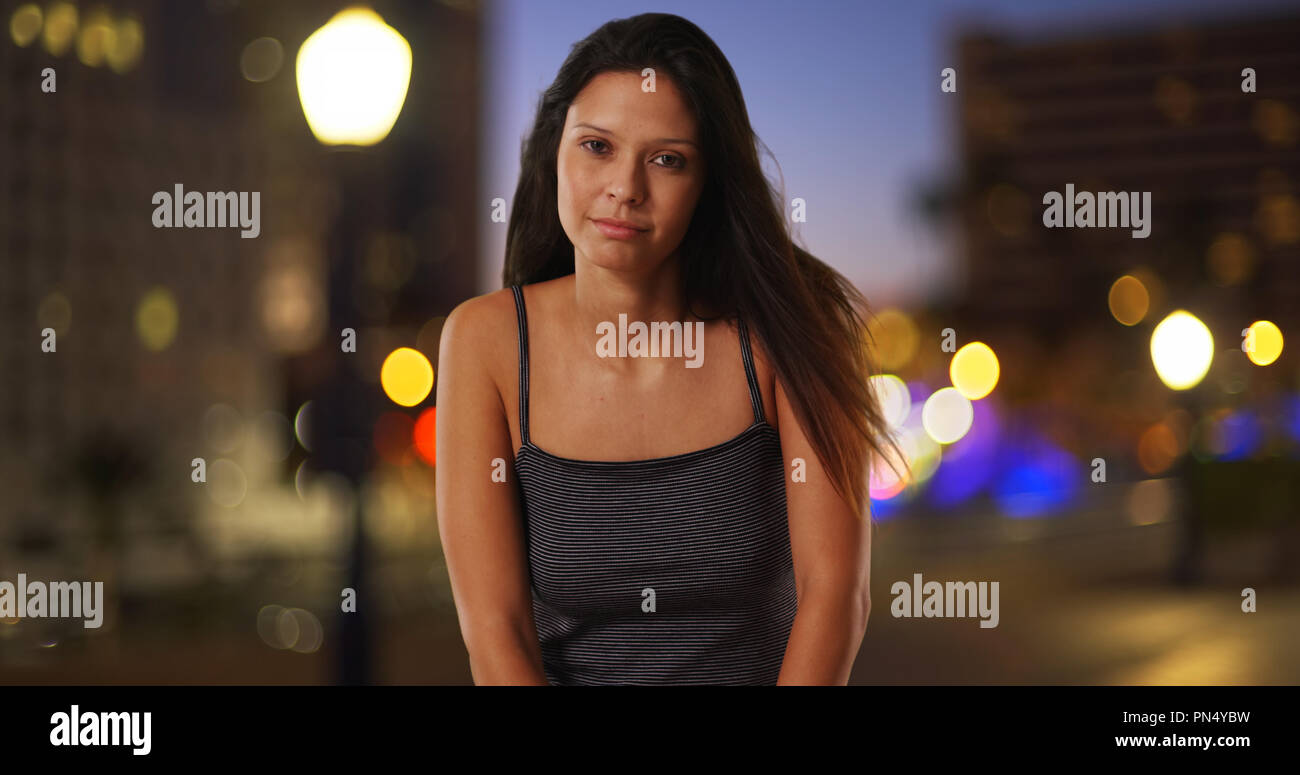 Caucasian girl wearing tank top in urban setting with pretty bokeh lights Stock Photo