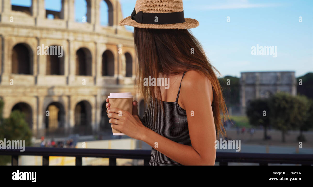 Beautiful young tourist woman with coffee standing near the Roman Coliseum Stock Photo