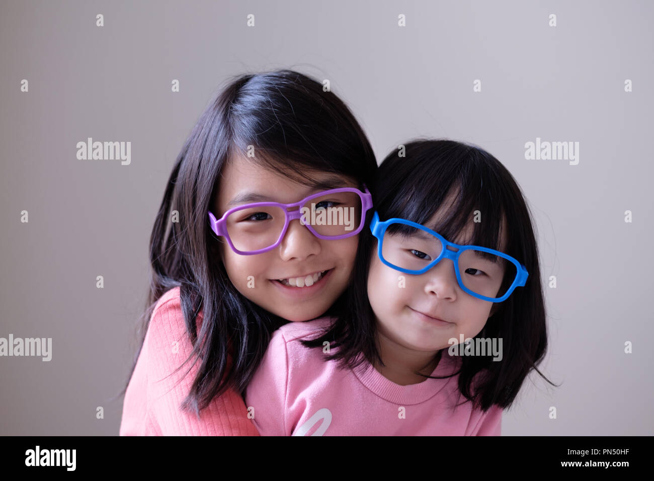 Two little sisters with big eyeglasses Stock Photo
