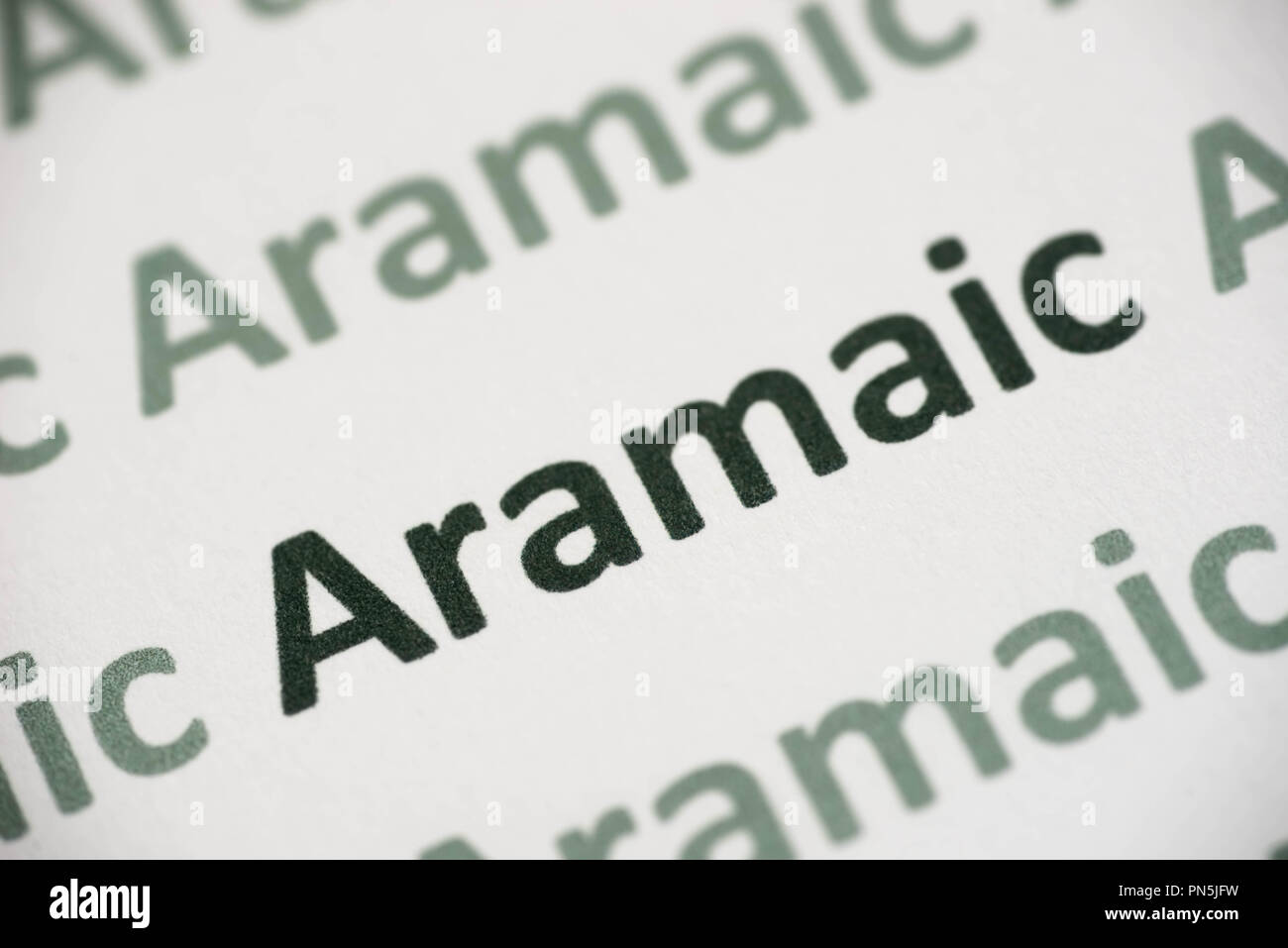 word Aramaic  language printed on white paper macro Stock Photo