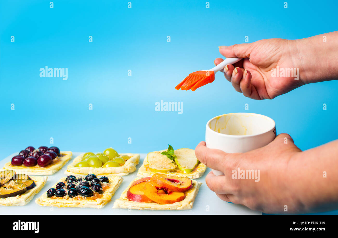 Chef applying egg on the fruit sweet pie before baking Stock Photo
