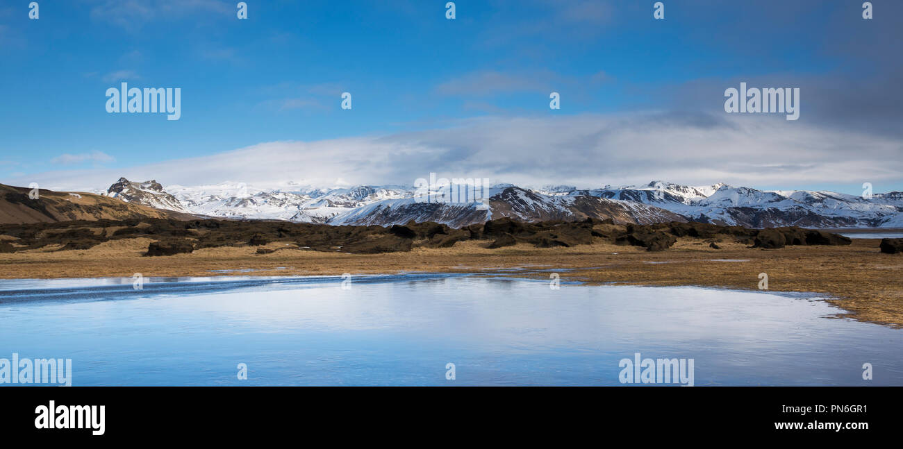 Typical Icelandic landscape of snow covered mountains and melting snow as winter turns to spring in South Iceland Stock Photo