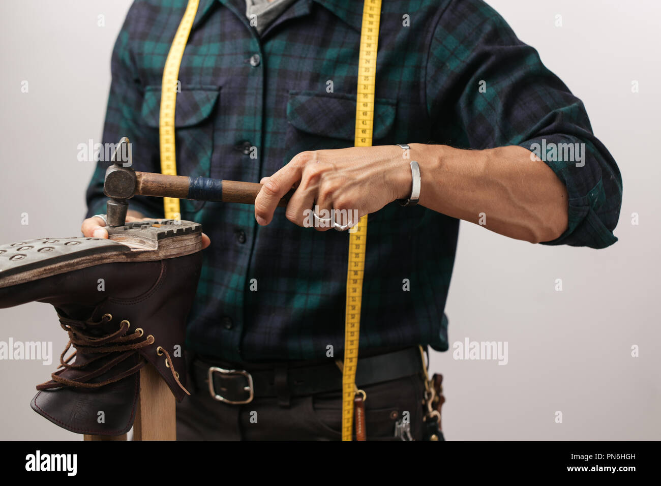 Cropped image of a shoemaker measuring a shoe with measure tape in Stock Photo Alamy
