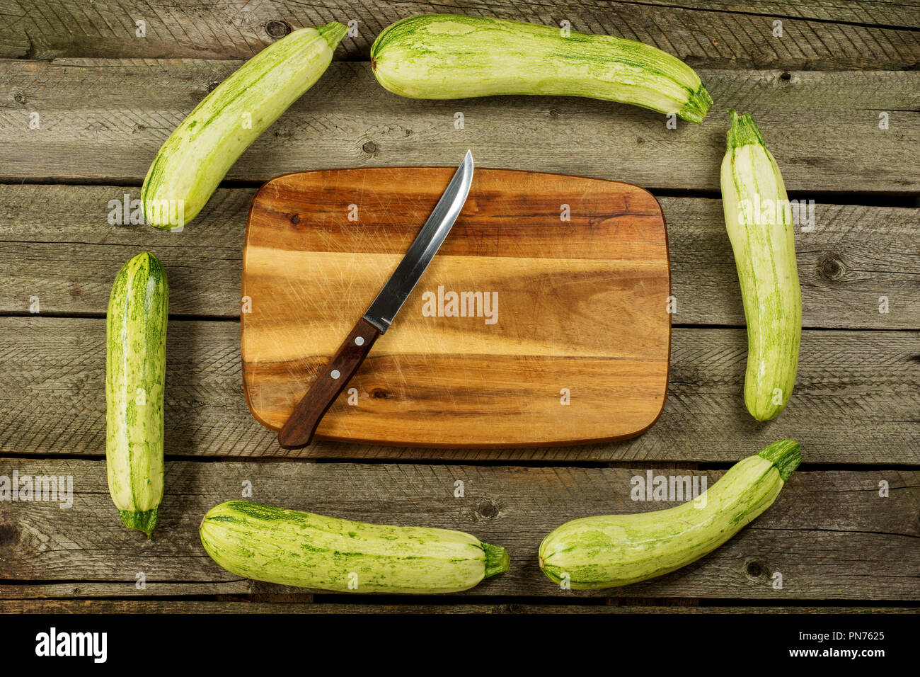 Light green fresh zucchini stacked, farm fresh produce, summer vegetables on rustic background. Top view Stock Photo