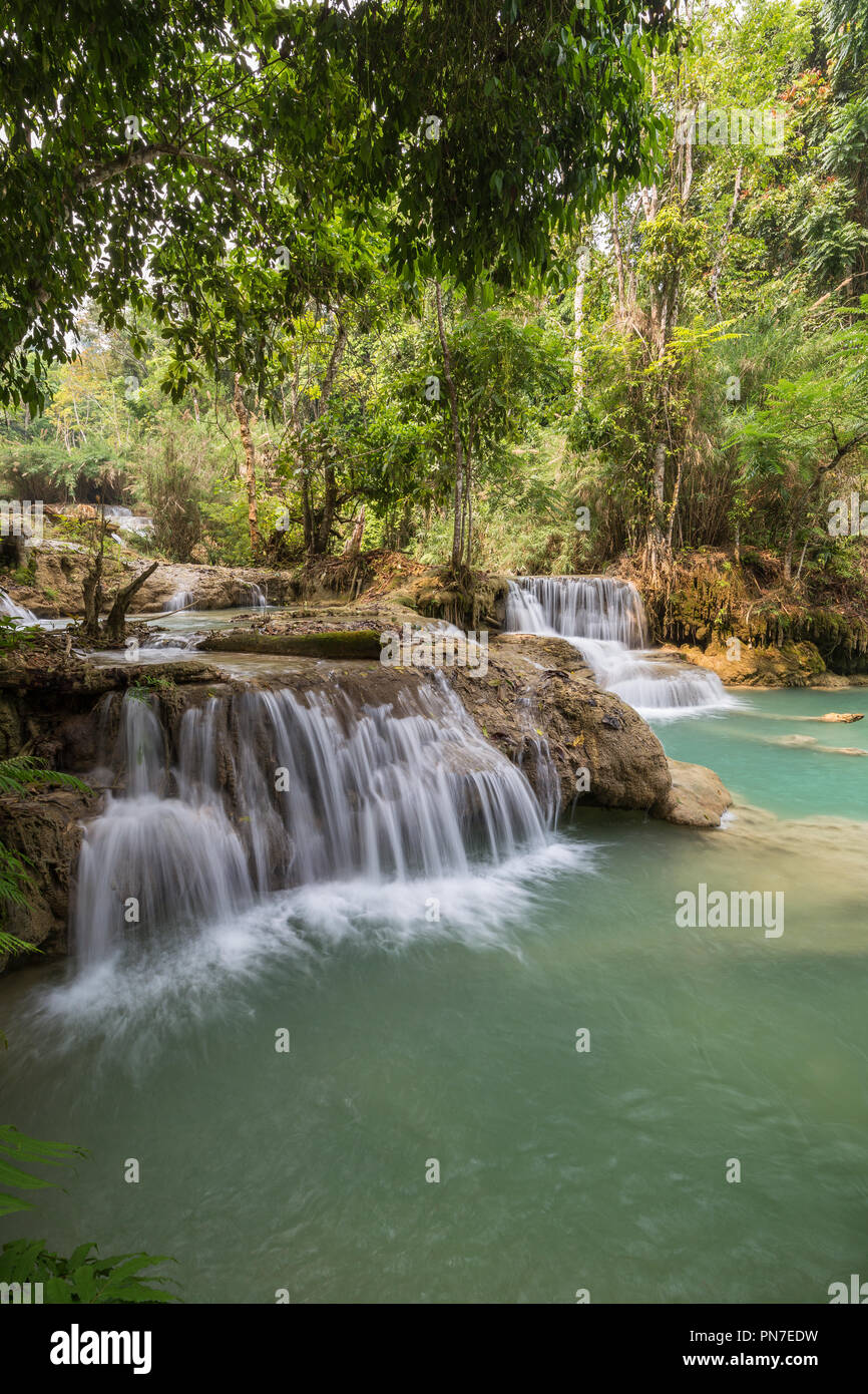 Beautiful view of several small cascades at the Tat Kuang Si Waterfalls near Luang Prabang in Laos on a sunny day. Stock Photo