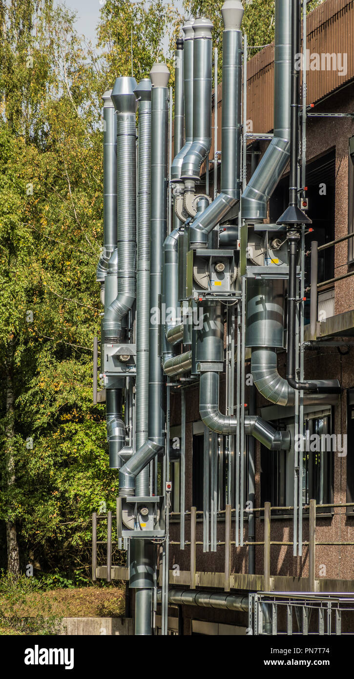 Abstract ensemble of shiny pipes on the wall of a building Stock Photo