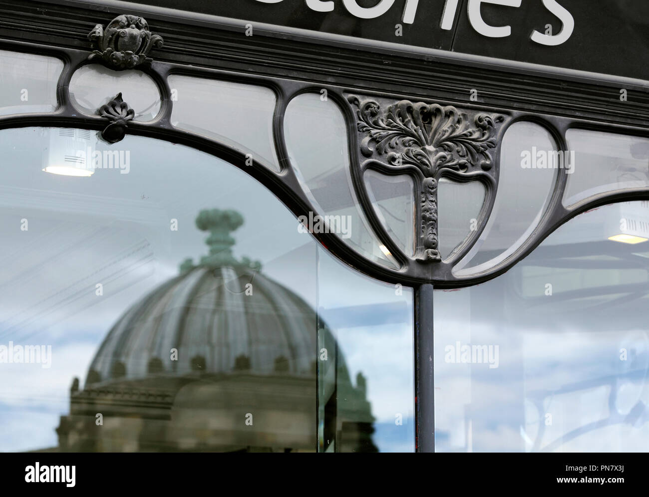 One of the domes of Newcastle upon Tyne's Market Arcade, reflected in the Art Nouveau style windows of Waterstone's bookshop on Blackett Street. Stock Photo