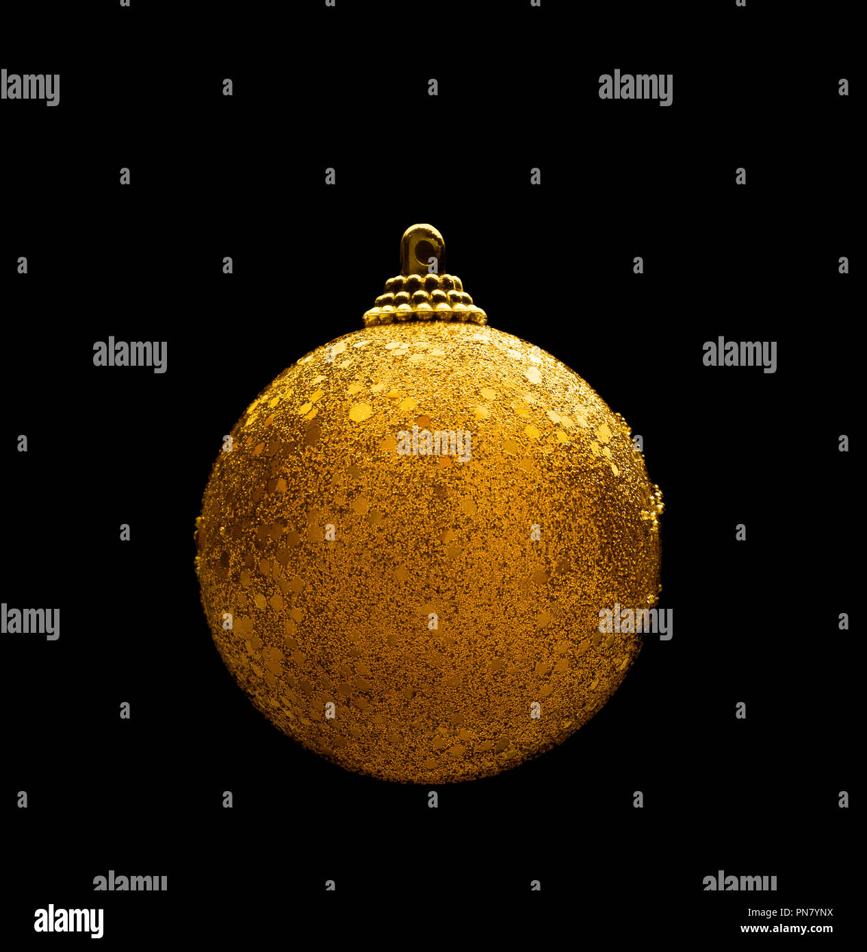 Golden color sparkling christmas ball isolated against black background Stock Photo
