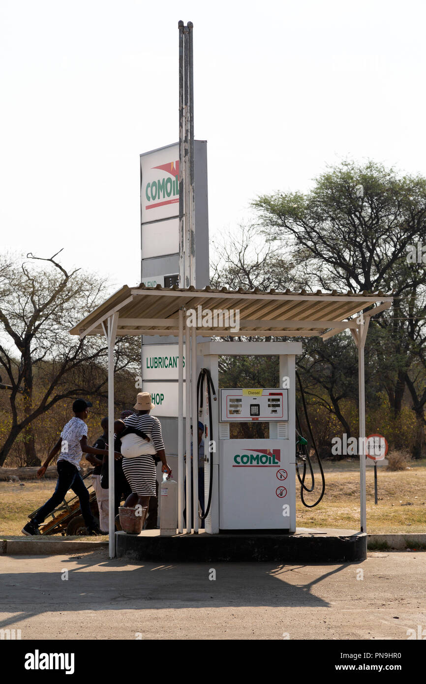 A fuel pump at a garage in Zimbabwe. Men walk close to the pump Stock