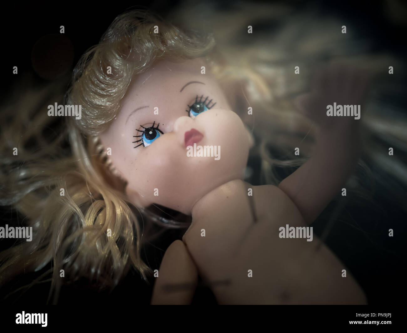 Close Up Dirty Baby Doll Blonde Hair With Pins On Dark Background