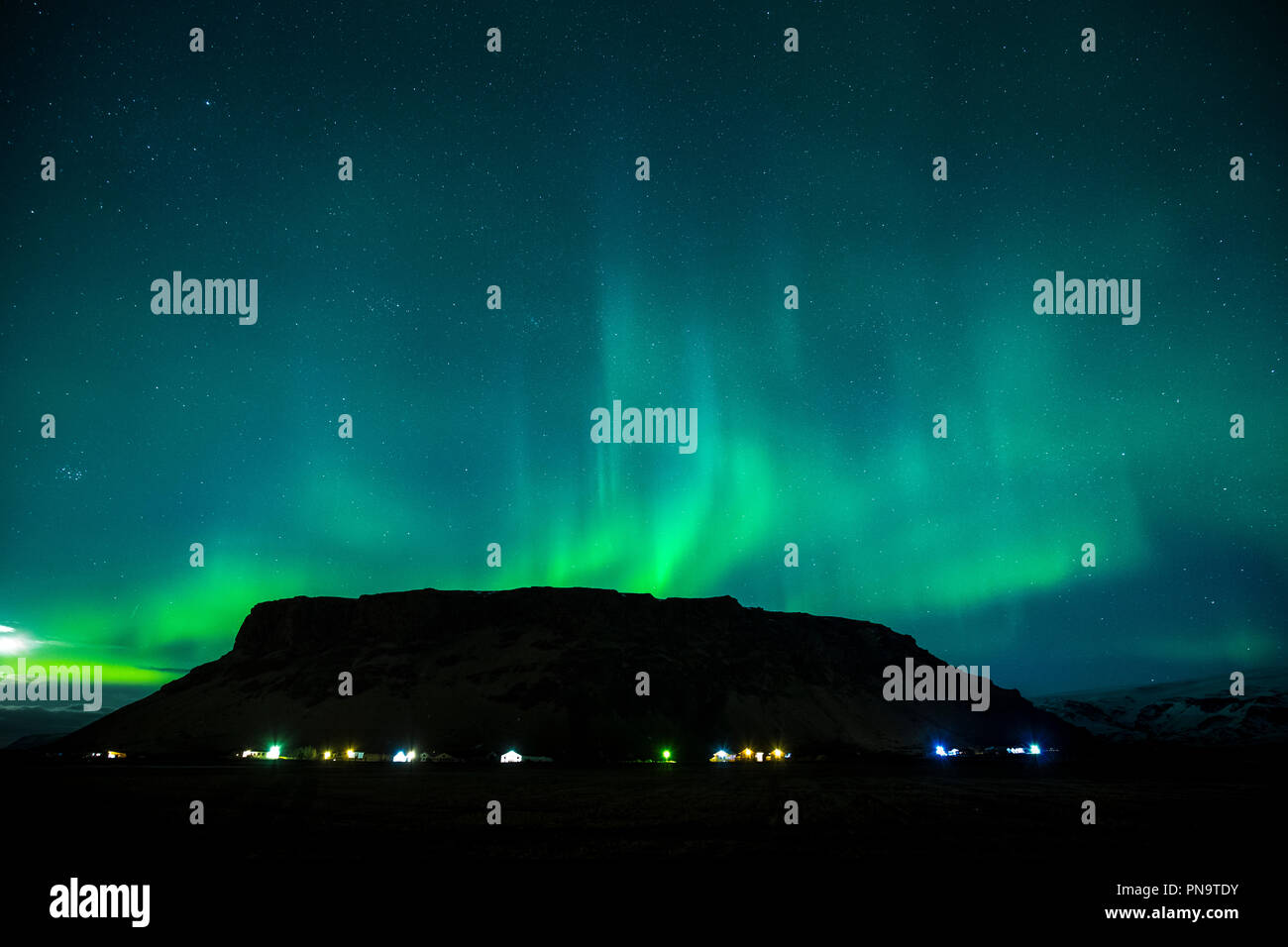 Aurora Borealis spectacular view of the Northern Lights in the sky over Mount Petursey Mountain at Vellir near Vik in South Iceland Stock Photo