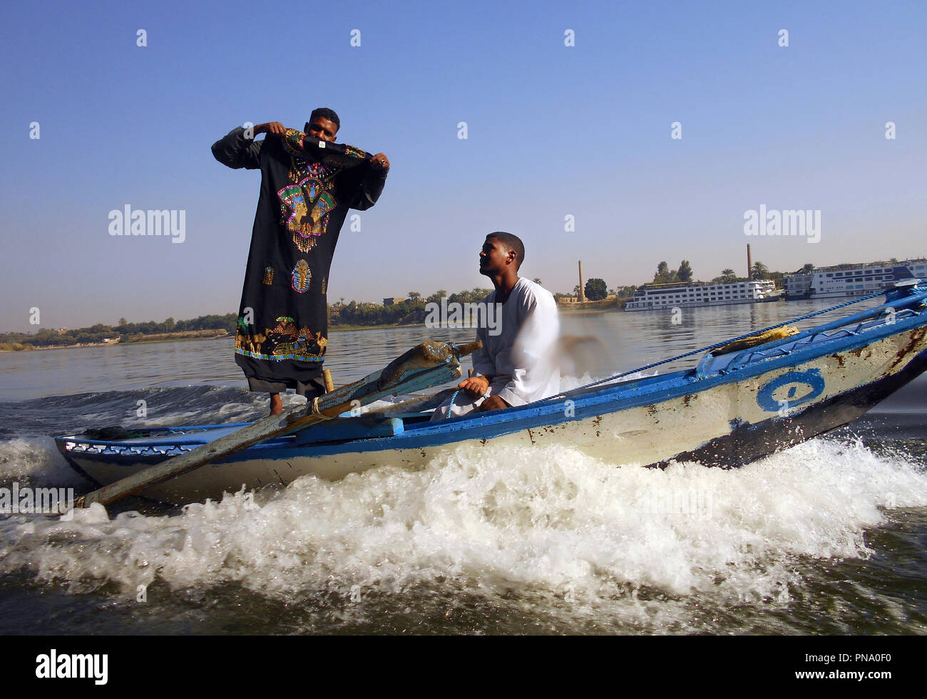 Two men in a fast boat try to sell carpets and other items to tourists on a  ship cruising down the Nile in Egypt. They gave up Stock Photo - Alamy
