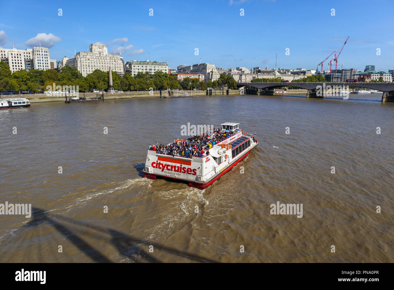 City Cruises cruise boat on the River Thames by Festival Pier and Waterloo Bridge, London, Shell-Mex House and Cleopatra's Needle on the Embankment Stock Photo
