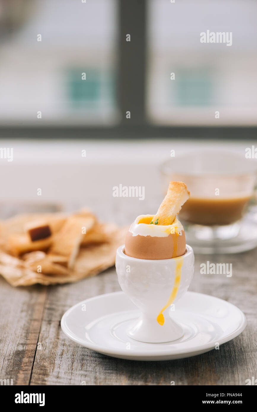 The yolk flows from boiled egg on toast Stock Photo