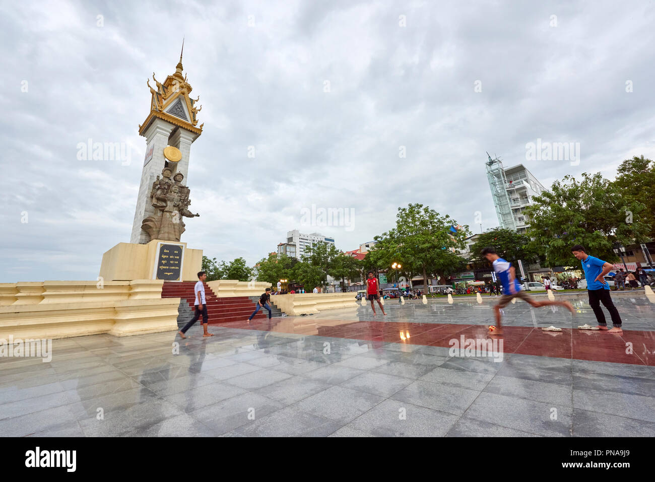 A group of boys play football in front of the Cambodia-Vietnam Friendship Monument in Botum Park, Phnom Penh, Cambodia. Stock Photo