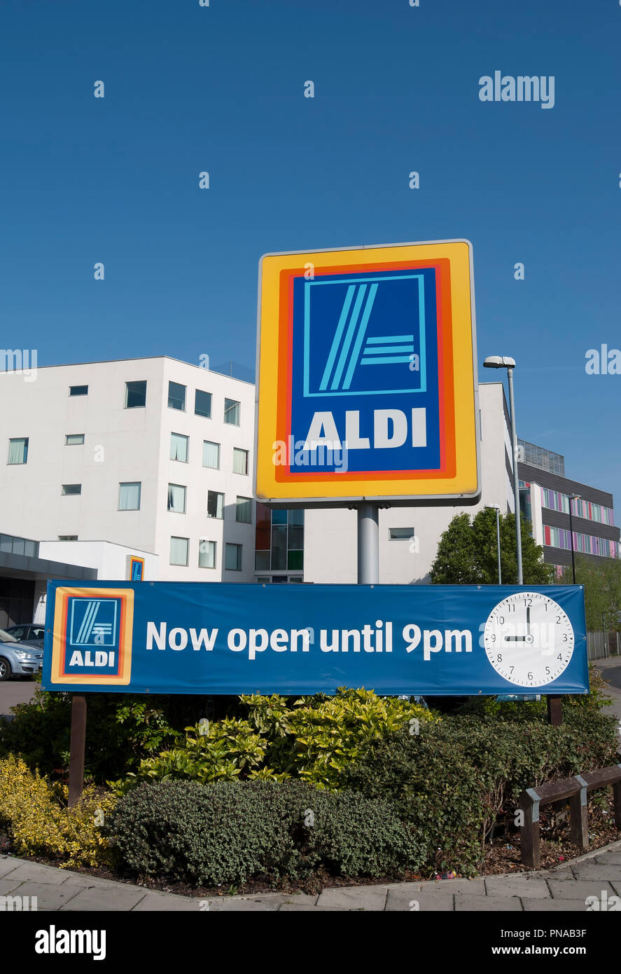 sign with name and logo of aldi, at a branch of the supermarket chain in hounslow, middlesex, england, with further sigh stating now open until 9pm Stock Photo