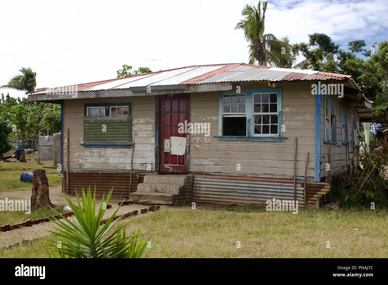 A family house with a corrugated roof inside a Tongan village on Atata Island, Kingdom of Tonga Stock Photo