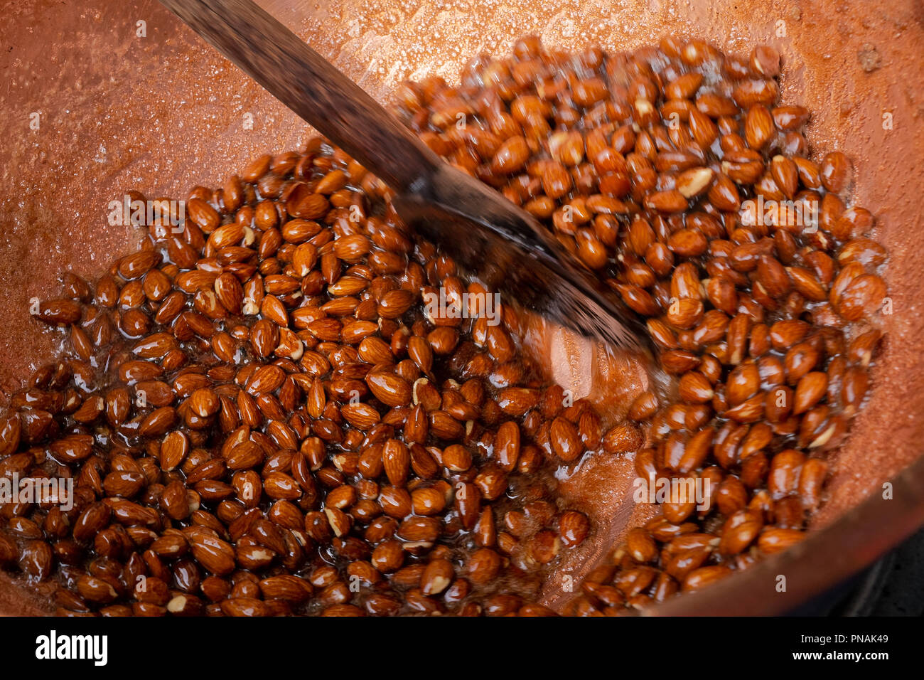 Sugar coated almonds being hand roasted. Stock Photo