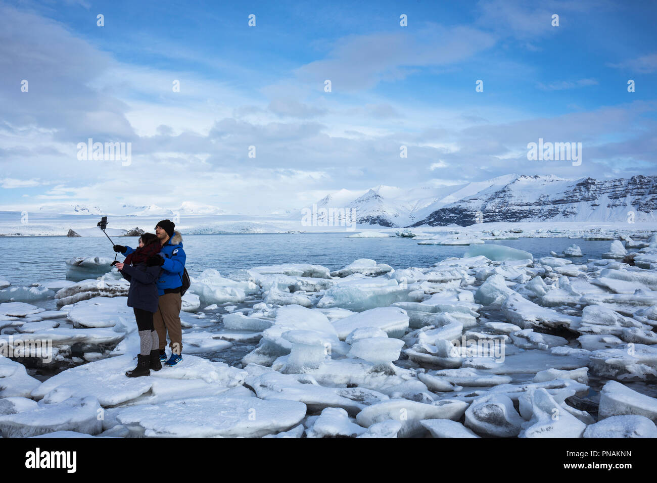 Tourists taking selfie photograph using smartphone for holiday photos at Jokulsarlon glacial lagoon, Vatnajokull National Park, South East Iceland Stock Photo